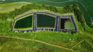 Case Study: Environmental Containment and Oil - Drone shot of triangular retention ponds in lush countryside, Harlington, UK.