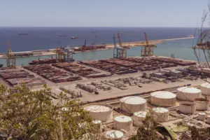 Environmental Containment with Ocean Geosynthetic Clay - A busy industrial port with cranes and cargo containers alongside th