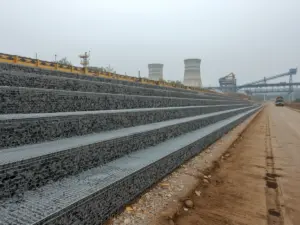 Stepped gabion retaining wall of double twisted hexagonal steel wire mesh beside a haul road at a coal power plant